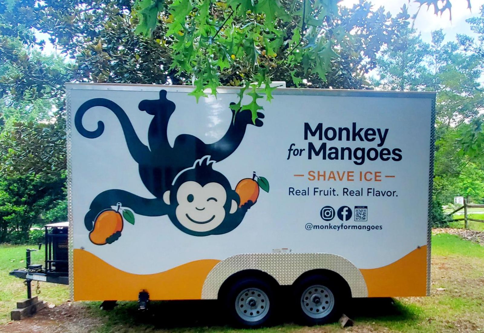 The Monkey for Mangoes shave ice trailer parked under the trees